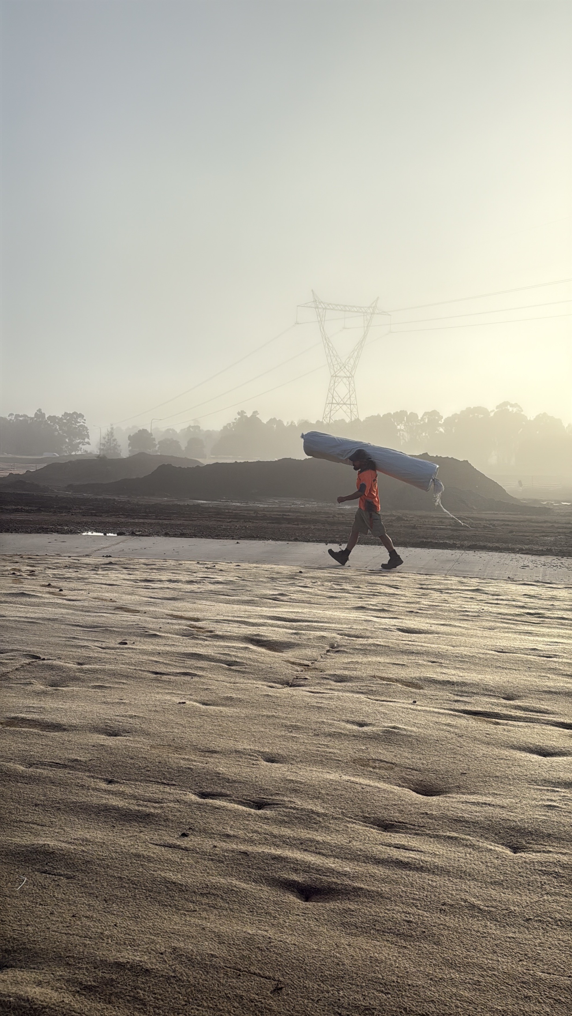 Crew laying jute matting at dawn, Marsden Park